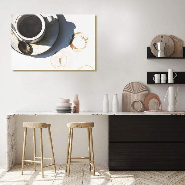 Modern kitchen interior with a painting of a coffee cup on the wall, wooden stools, and kitchenware.