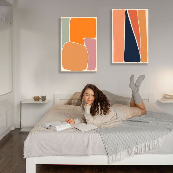 Woman lying on a bed reading a book with abstract art on the wall.