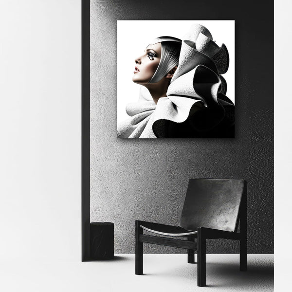 Black and white portrait of a woman on a textured wall with a chair below.